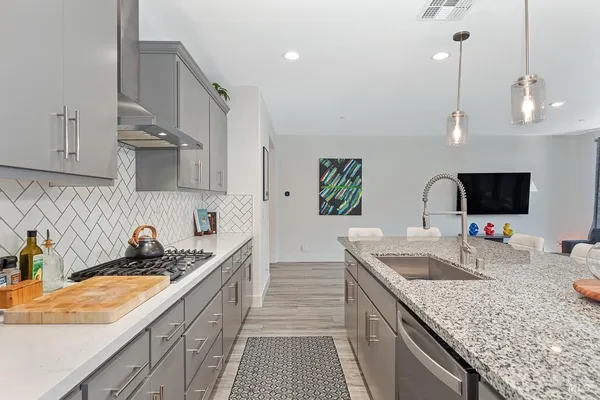 a kitchen with granite countertop a sink a counter top space and cabinets
