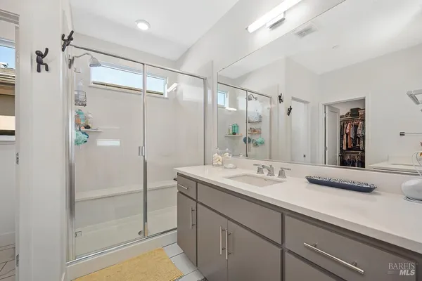 a bathroom with a shower sink and mirror