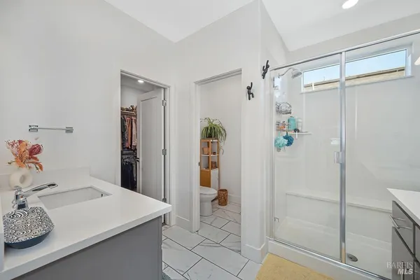 a bathroom with a sink vanity and shower