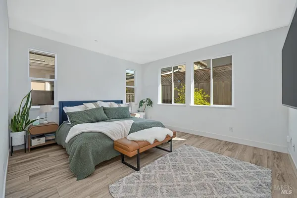 a spacious bedroom with a bed and wooden floor