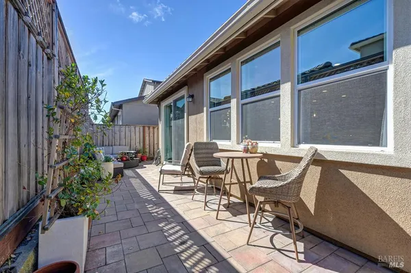 a view of a patio with a table and chairs and potted plants