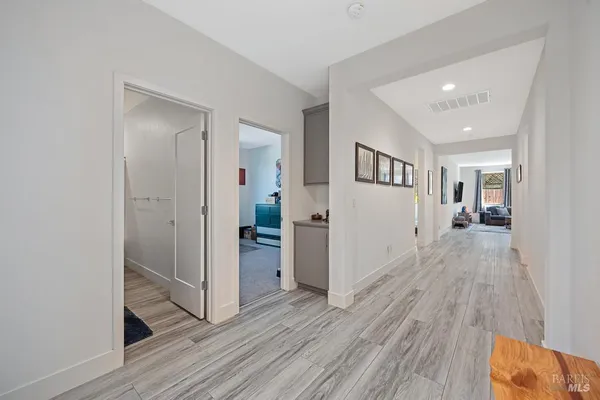 a view of a hallway with wooden floor and closet