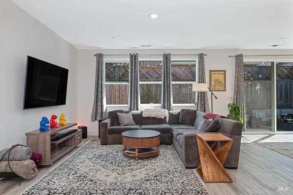 a living room with furniture flat screen tv and a floor to ceiling window