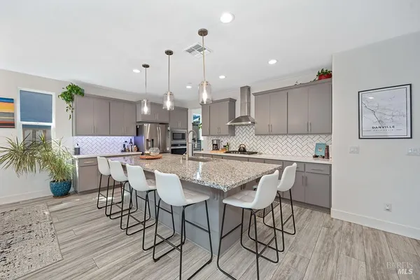 a kitchen with stainless steel appliances kitchen island a table and chairs in it