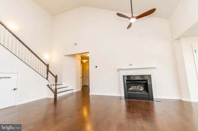 a living room with wooden floor and a fireplace