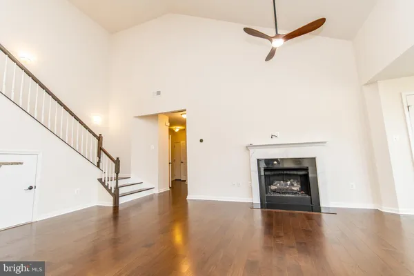 a living room with wooden floor and a fireplace