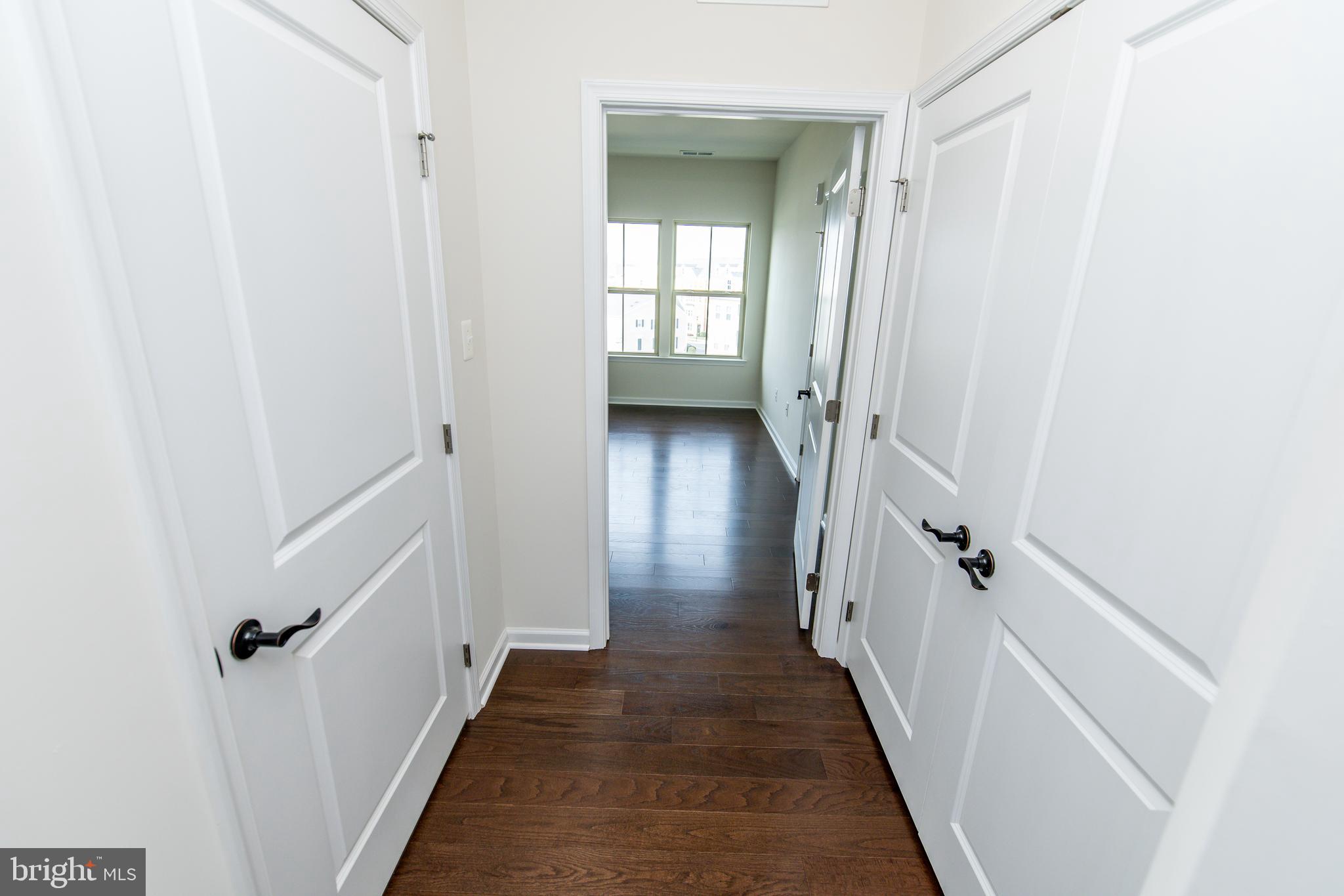 4861 Finnical Way, Unit 401 Frederick, MD 21703 - Photo 24 of 54 a view of a hallway with wooden floor and staircase