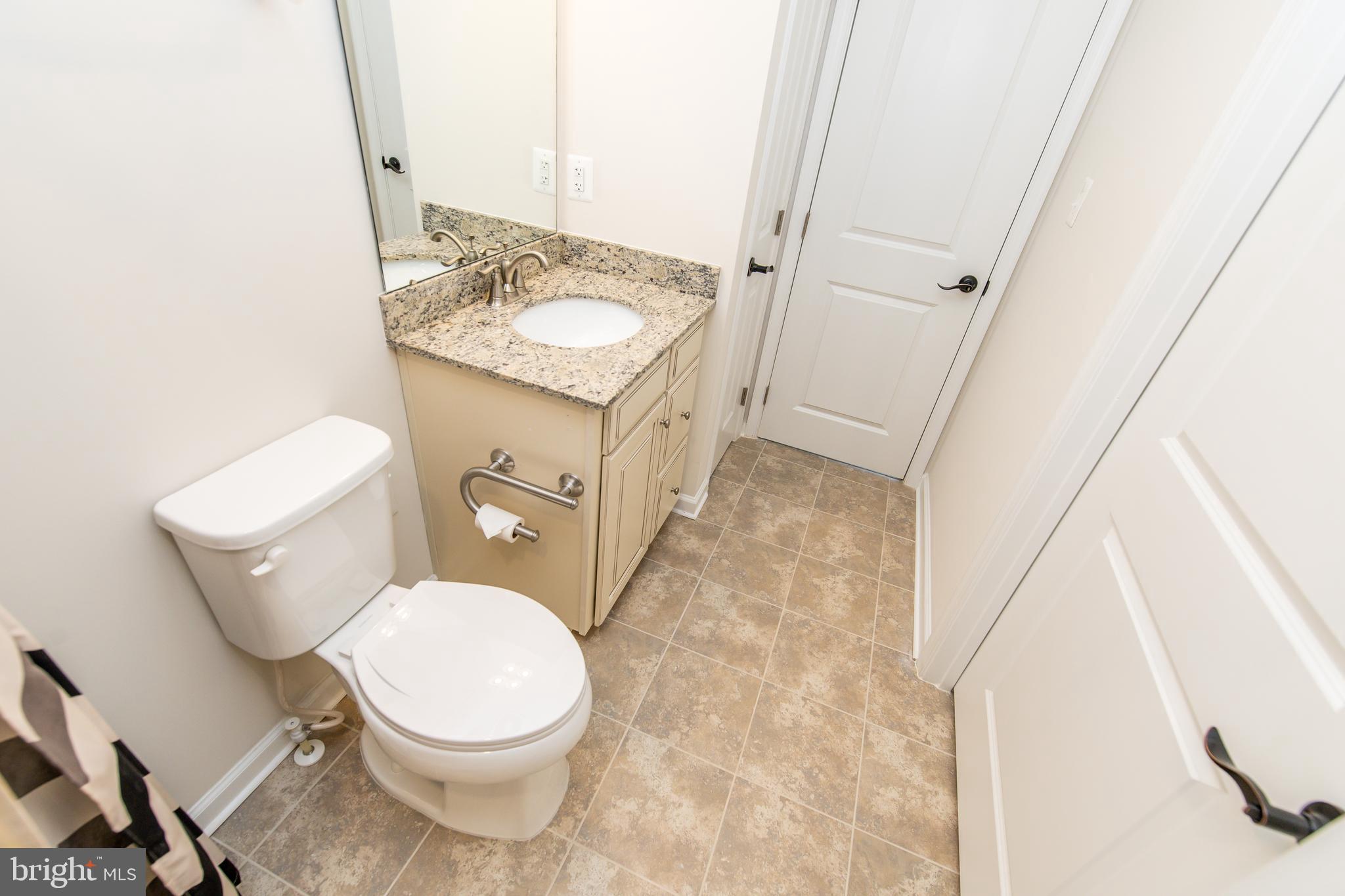 4861 Finnical Way, Unit 401 Frederick, MD 21703 - Photo 26 of 54 a white toilet sitting next to a bathroom sink