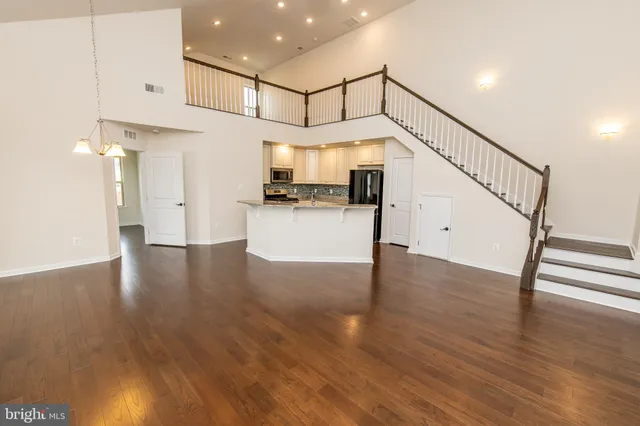 a view of staircase and kitchen with wooden floor