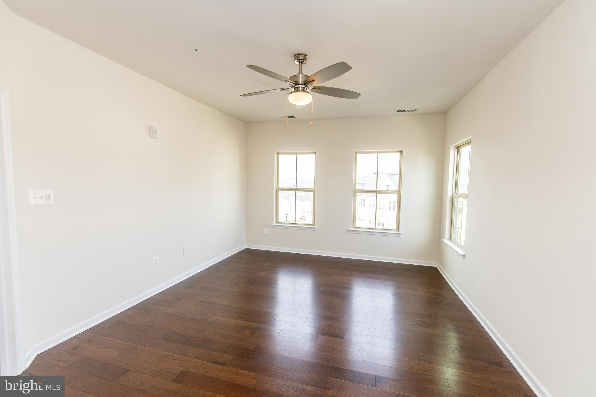 4861 Finnical Way, Unit 401 Frederick, MD 21703 - Photo 32 of 54 a view of an empty room with window and wooden floor