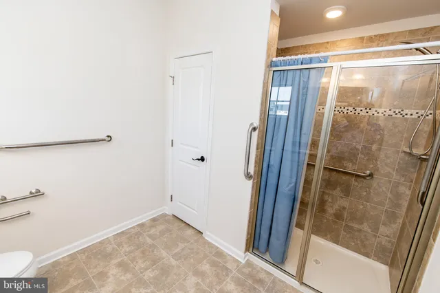 a bathroom with a granite countertop toilet sink and mirror