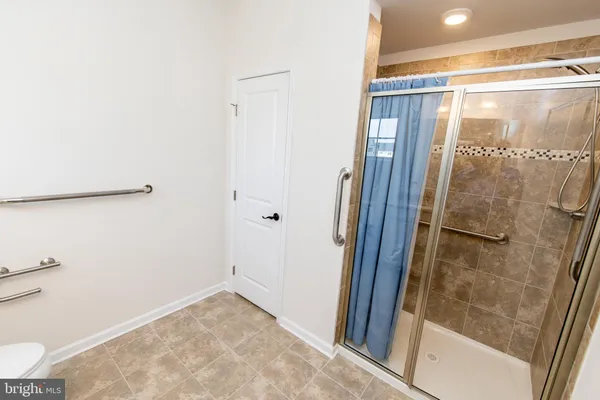 a bathroom with a granite countertop toilet sink and mirror