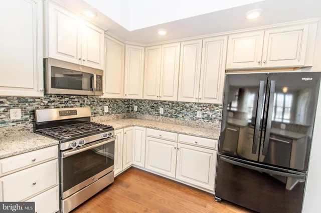 a kitchen with granite countertop stainless steel appliances and wooden cabinets