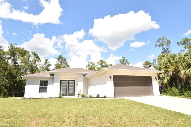 a front view of a house with a garden and yard