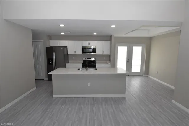 a view of a kitchen with a sink and a refrigerator