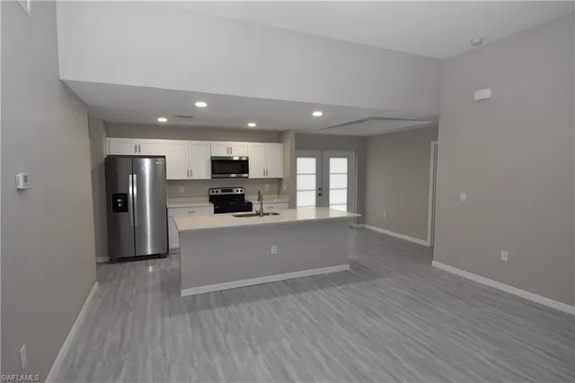 a view of a kitchen with a sink and a refrigerator