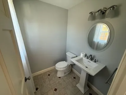 a bathroom with a sink toilet and a mirror