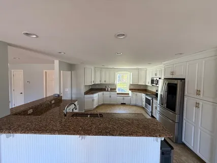 a kitchen with stainless steel appliances granite countertop a sink refrigerator and stove