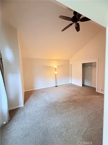 a view of a room with an empty space and a ceiling fan