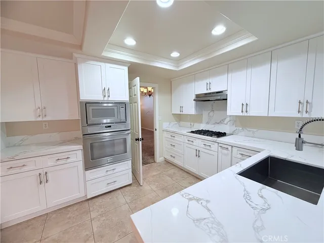 a kitchen with white cabinets and appliances