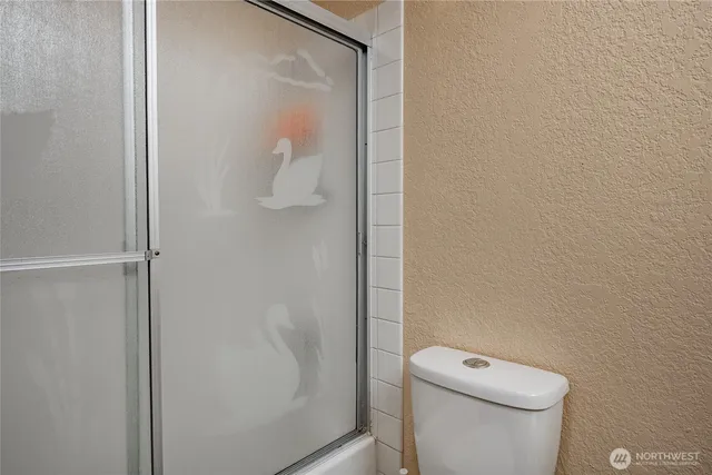 a white toilet sitting next to a shower