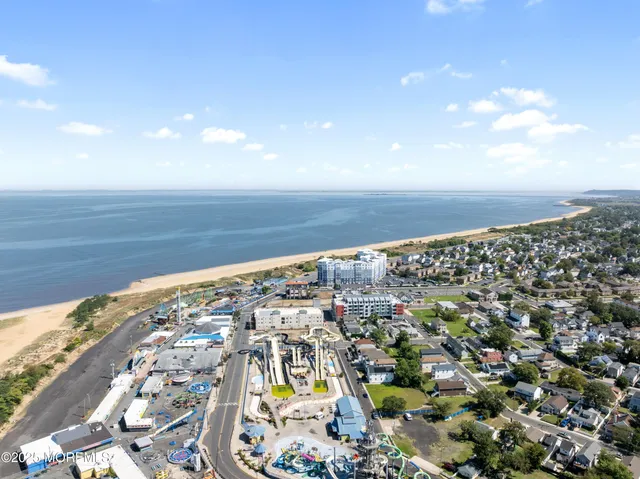 an aerial view of a house with a yard and large trees