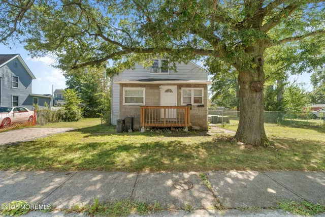 a view of a house with a tree in front of it