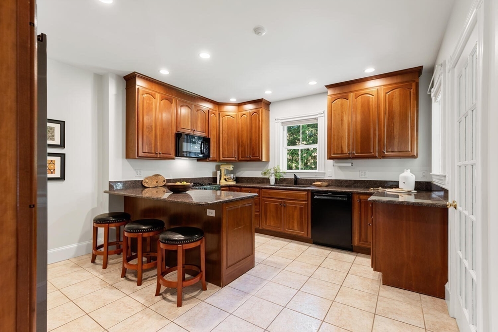 9 Bacon Street, Unit 9 Winchester, MA 01890 - Photo 11 of 35 a kitchen with kitchen island granite countertop a sink counter top space appliances and cabinets