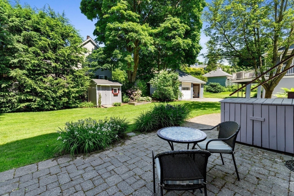 9 Bacon Street, Unit 9 Winchester, MA 01890 - Photo 30 of 35 a view of a table and chairs in backyard of the house