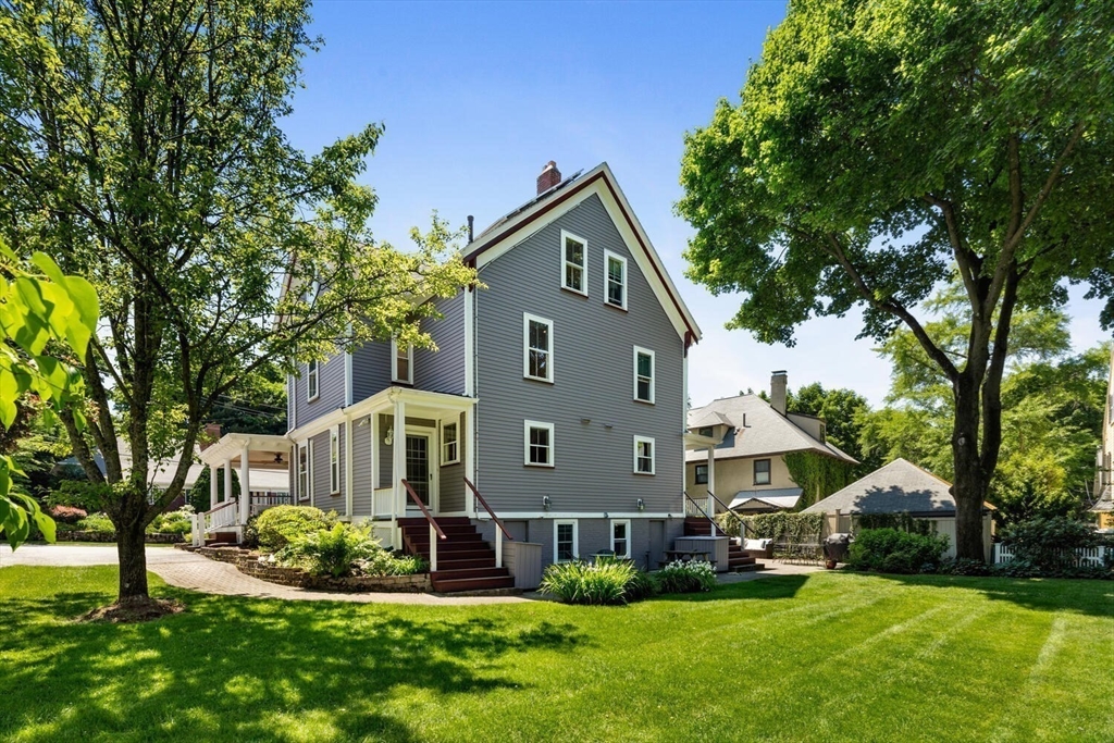 9 Bacon Street, Unit 9 Winchester, MA 01890 - Photo 3 of 35 a front view of a house with a yard and trees