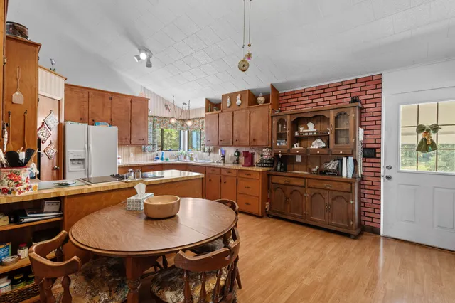 a kitchen with kitchen island a stove a sink a dining table and chairs