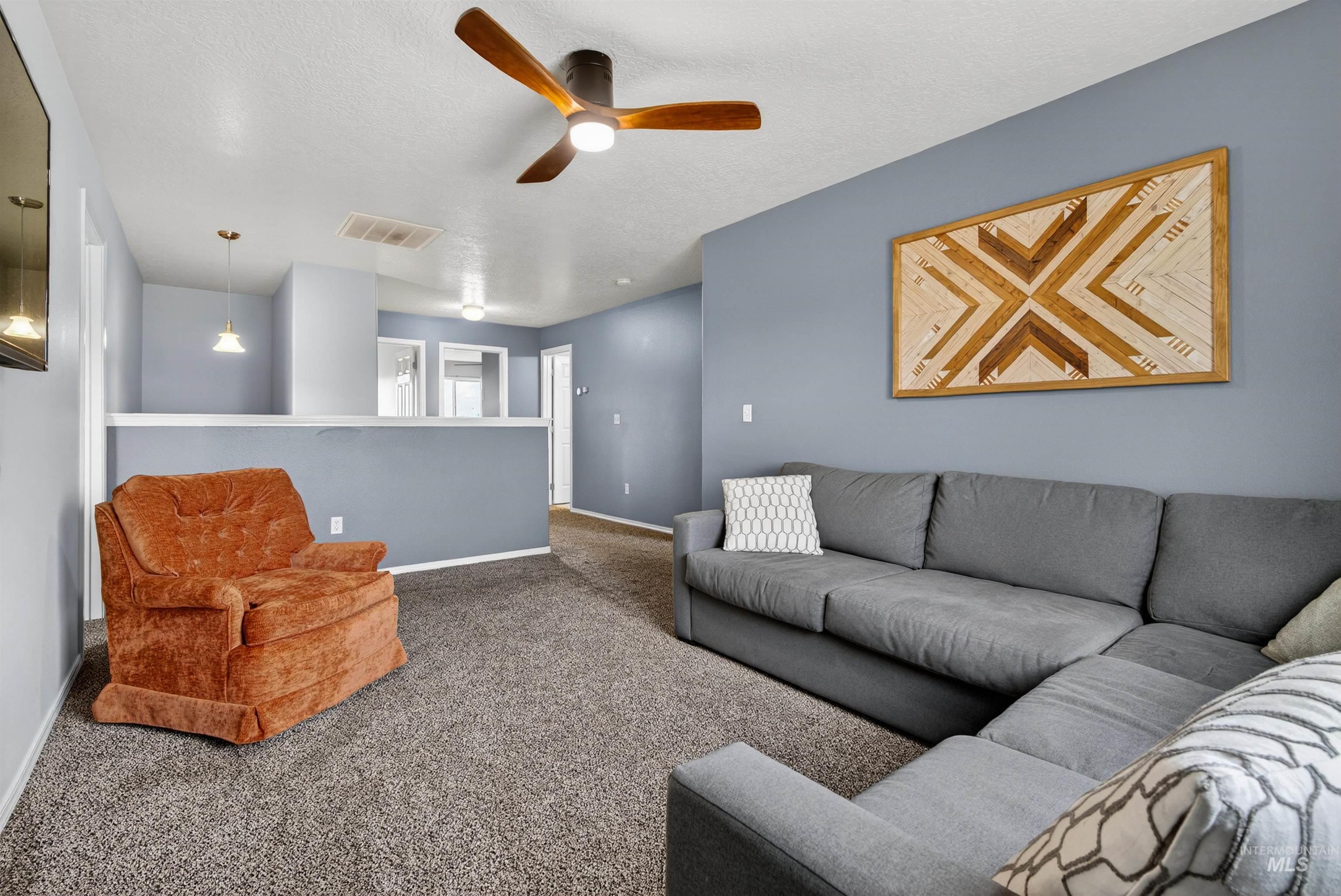 5414 Barkley Way Caldwell, ID 83607 - Photo 16 of 50 Living area with a ceiling fan, carpet floors, and a textured ceiling