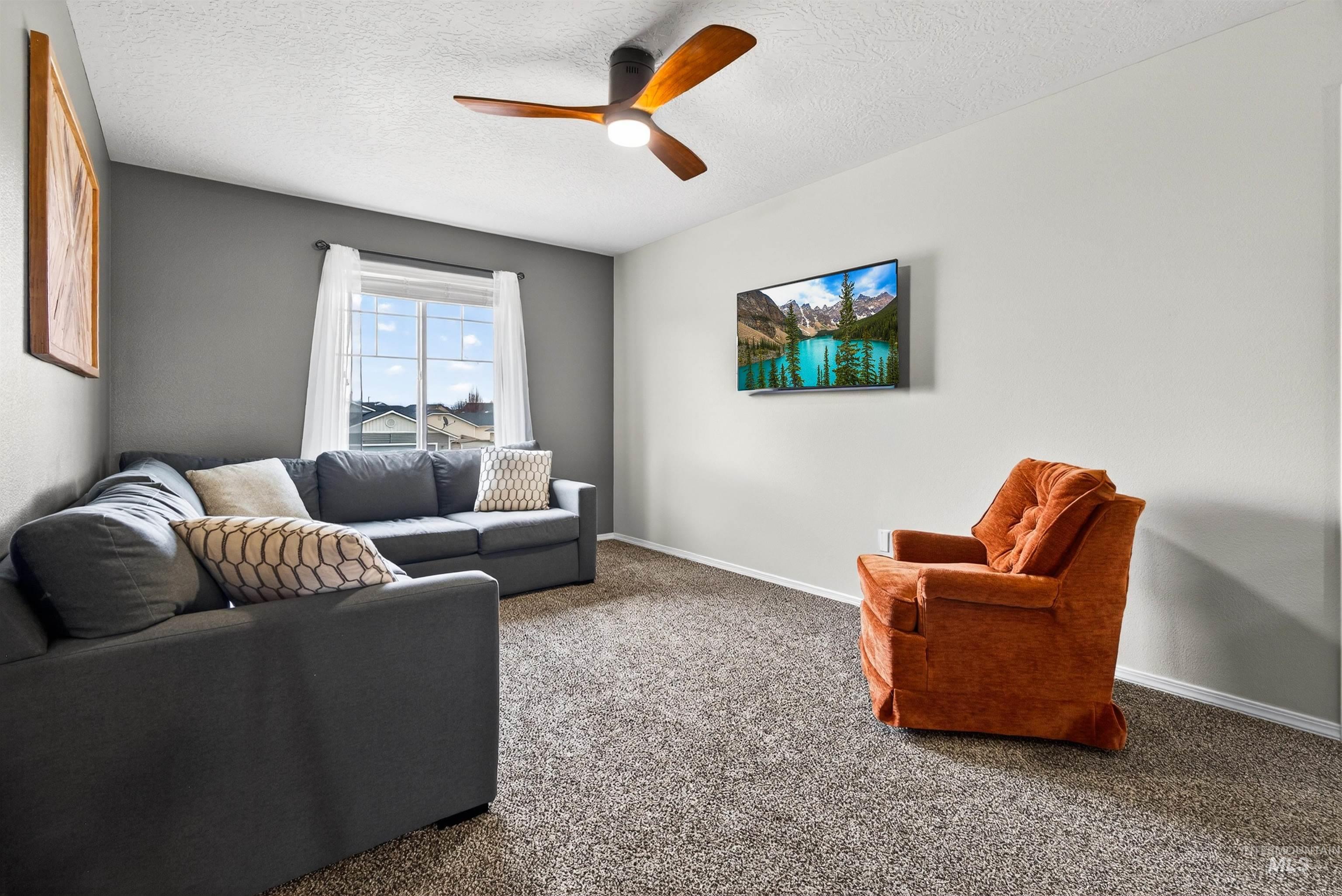 5414 Barkley Way Caldwell, ID 83607 - Photo 17 of 50 Carpeted living area featuring a ceiling fan and a textured ceiling