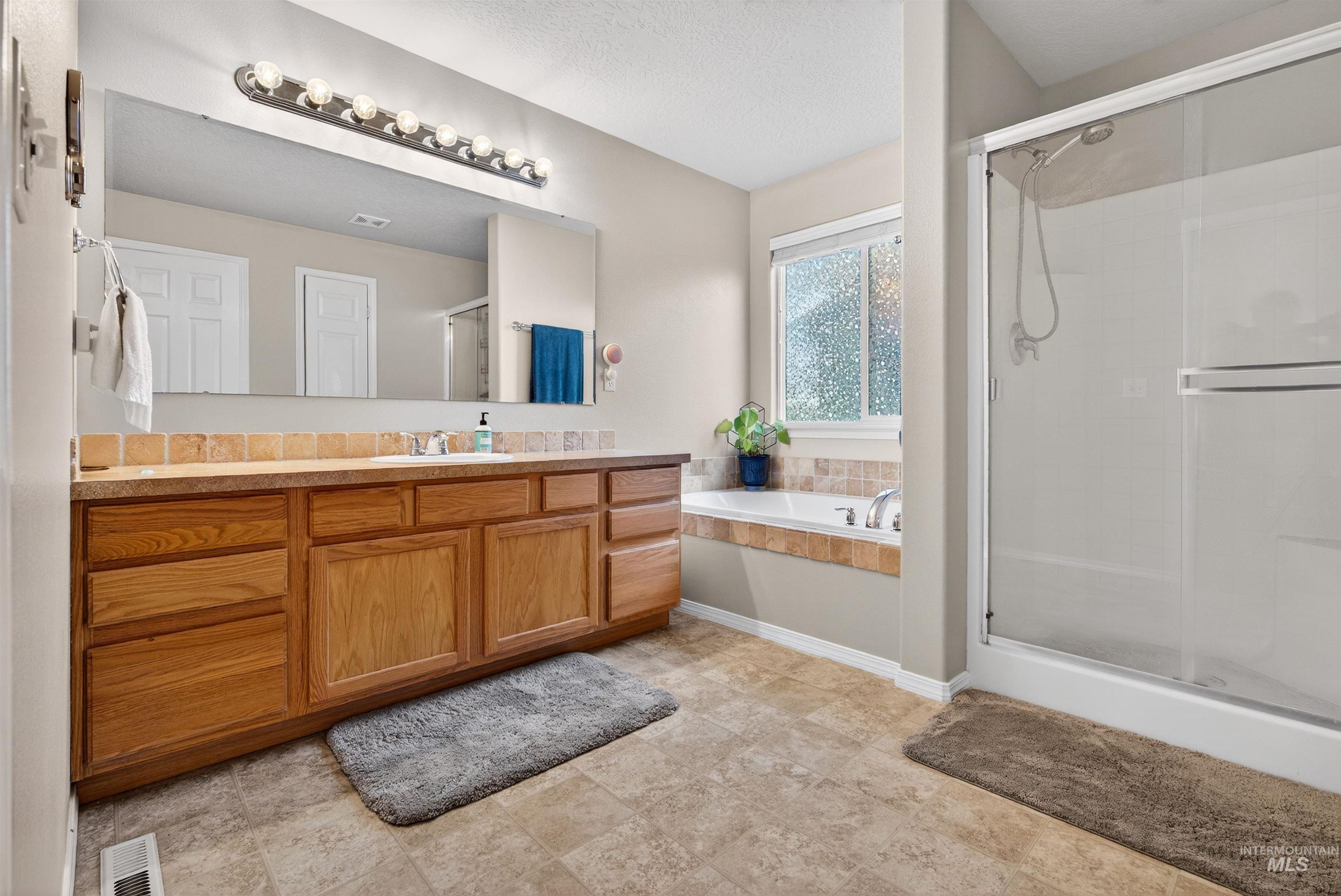 5414 Barkley Way Caldwell, ID 83607 - Photo 20 of 50 Bathroom with vanity, a stall shower, and a bath