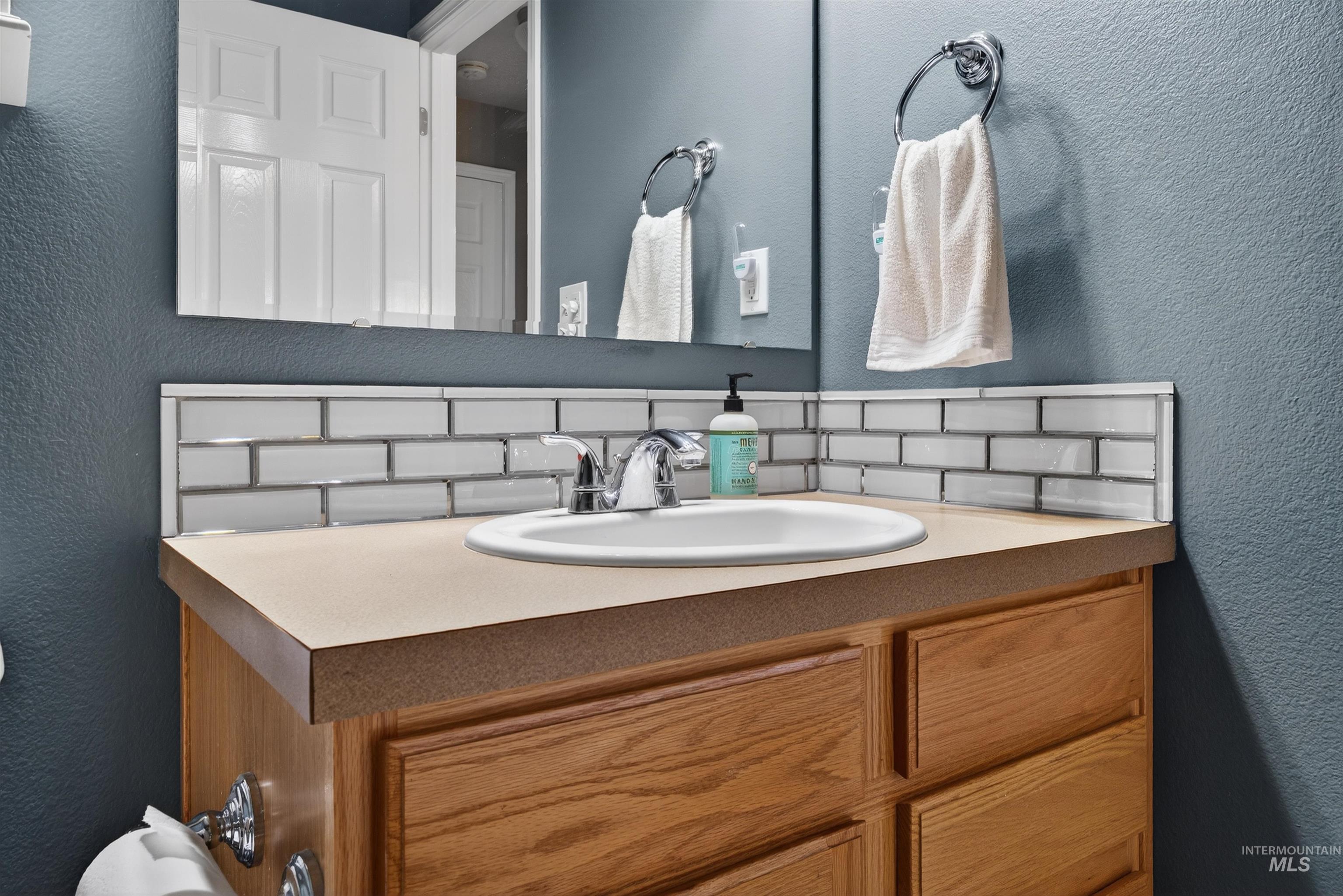 5414 Barkley Way Caldwell, ID 83607 - Photo 27 of 50 Bathroom featuring a textured wall, vanity, and backsplash