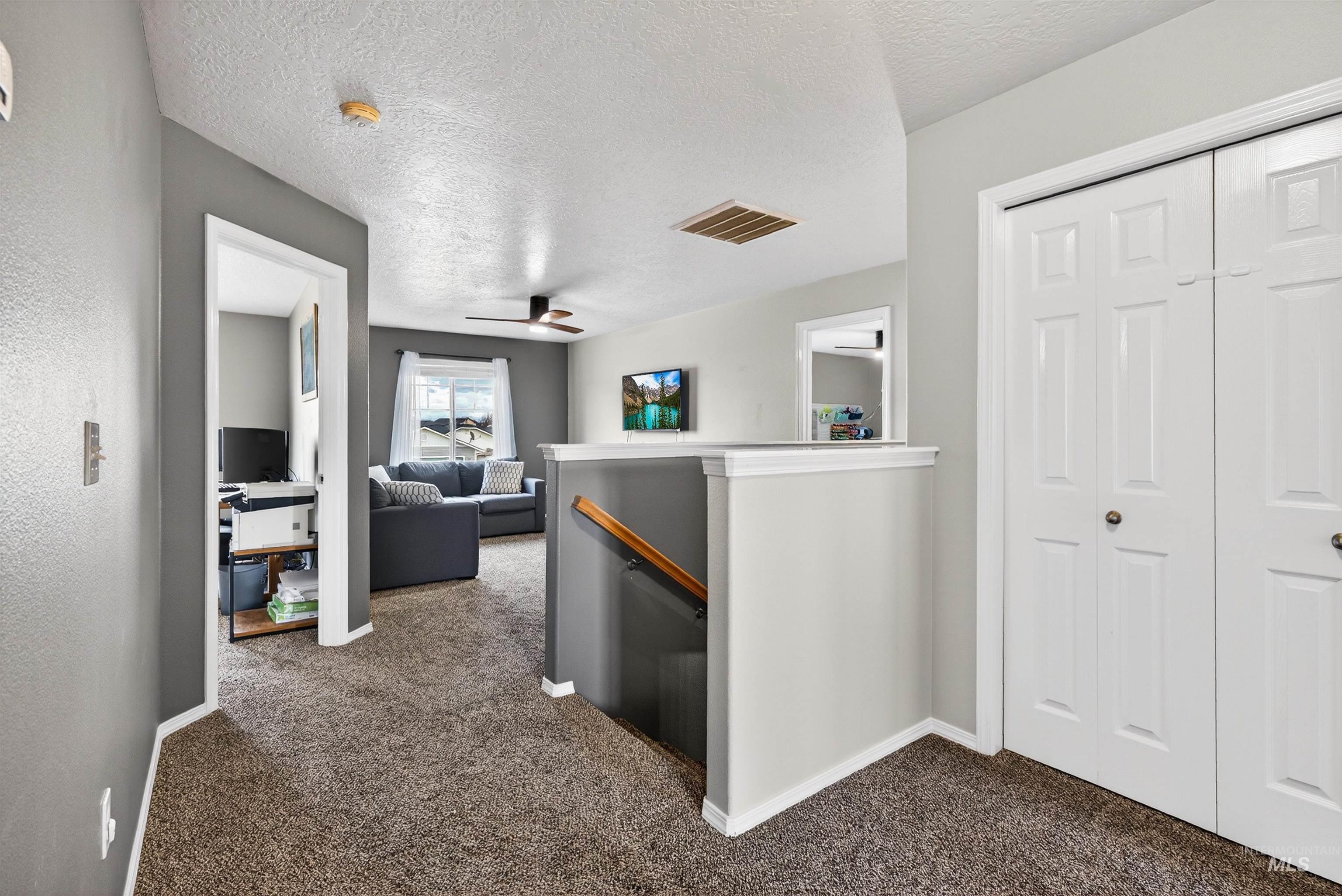 5414 Barkley Way Caldwell, ID 83607 - Photo 29 of 50 Hall featuring an upstairs landing, dark colored carpet, and a textured ceiling