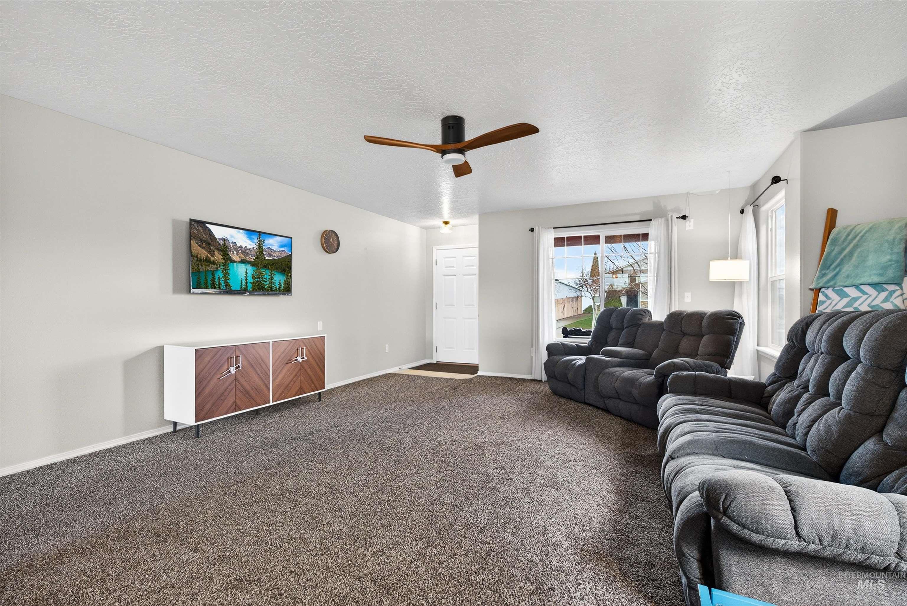 5414 Barkley Way Caldwell, ID 83607 - Photo 3 of 50 Living room with a textured ceiling, carpet floors, and a ceiling fan