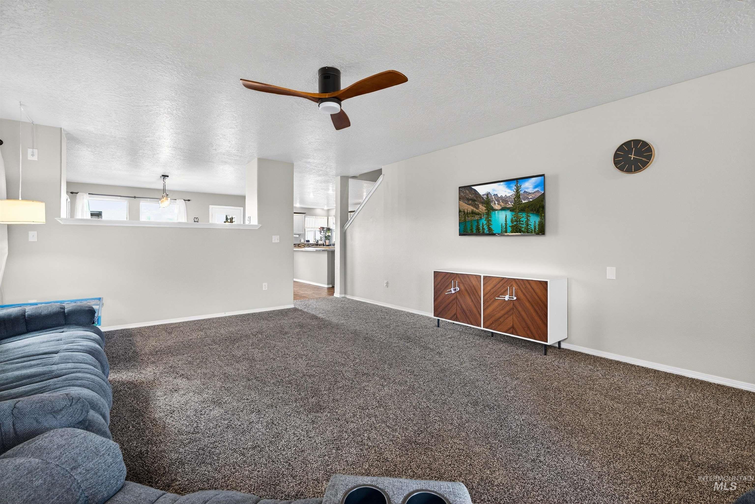 5414 Barkley Way Caldwell, ID 83607 - Photo 6 of 50 Living room with a textured ceiling, ceiling fan, and carpet floors