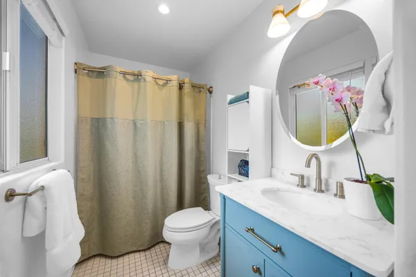 a bathroom with a granite countertop sink mirror vanity and toilet