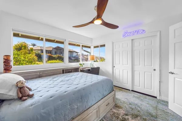 a bedroom with a bed and a large window