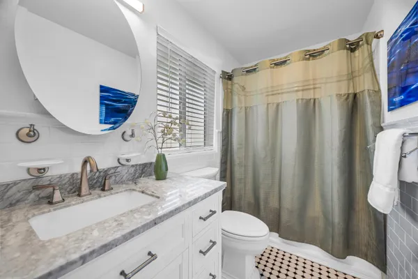 a bathroom with a granite countertop sink and a mirror