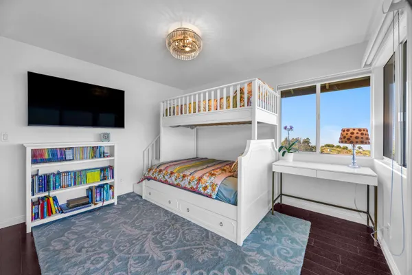 a living room with baby crib furniture and a flat screen tv