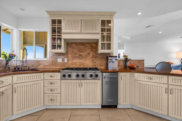 a kitchen with stainless steel appliances granite countertop a stove a sink and a microwave