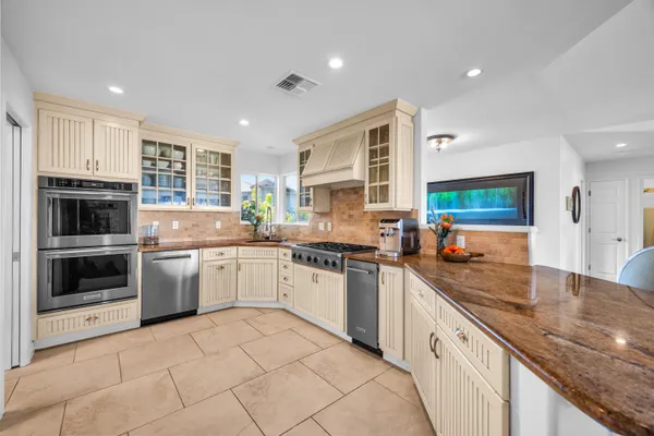 a kitchen with stainless steel appliances granite countertop a stove sink and cabinets