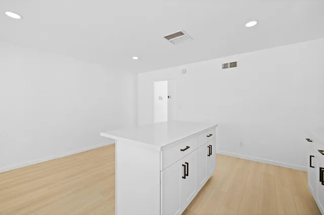 a kitchen with granite countertop white cabinets and stainless steel appliances