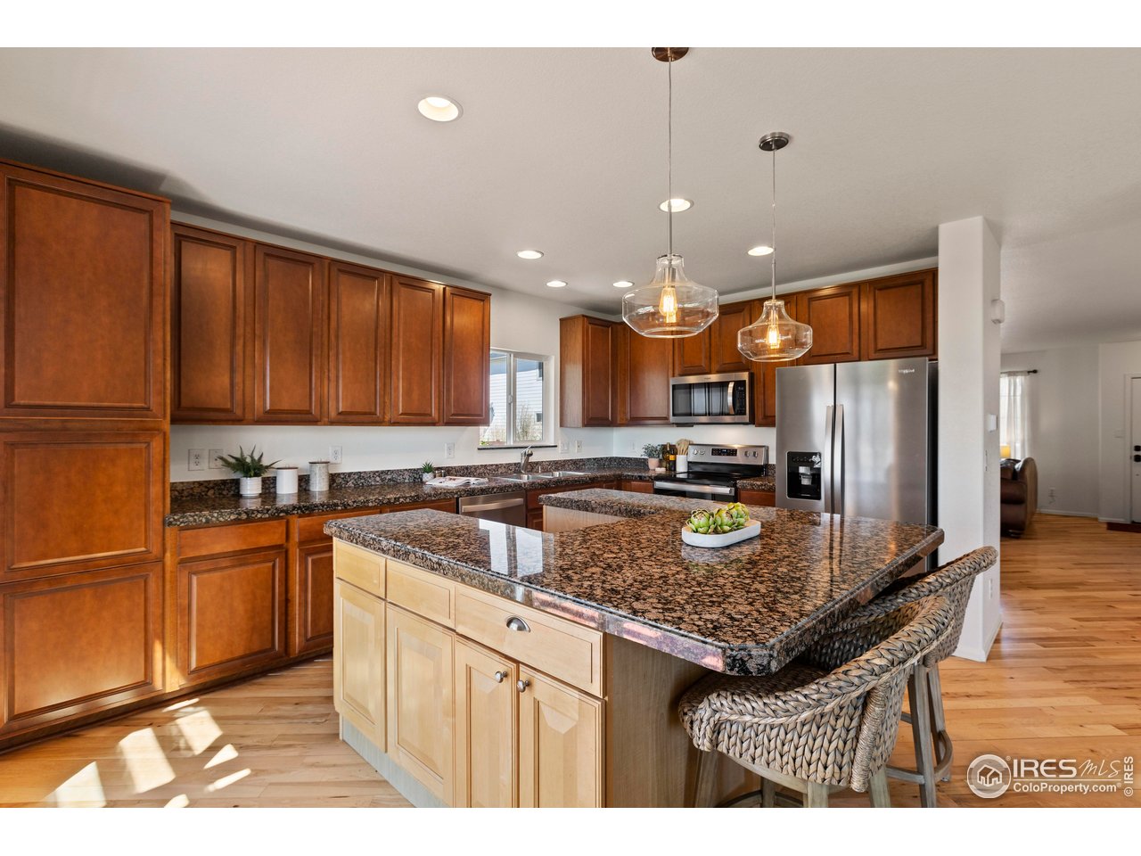 6117 Gold Dust Road Timnath, CO 80547 - Photo 14 of 43 a kitchen with stainless steel appliances granite countertop a sink stove and refrigerator