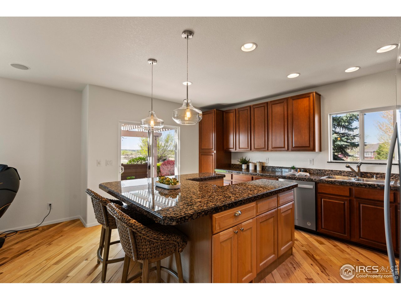 6117 Gold Dust Road Timnath, CO 80547 - Photo 15 of 43 a kitchen with a sink a counter space and wooden floor