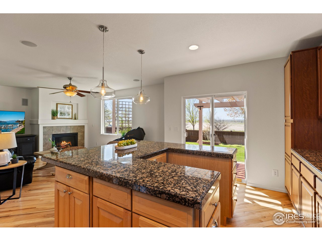 6117 Gold Dust Road Timnath, CO 80547 - Photo 16 of 43 a kitchen with granite countertop a stove a sink a refrigerator and wooden floor
