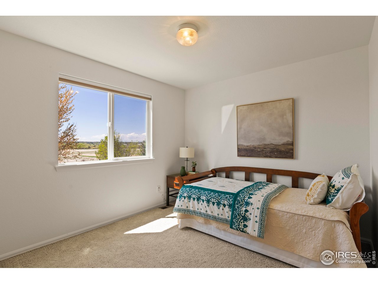 6117 Gold Dust Road Timnath, CO 80547 - Photo 24 of 43 a bedroom with a bed and painting on the wall