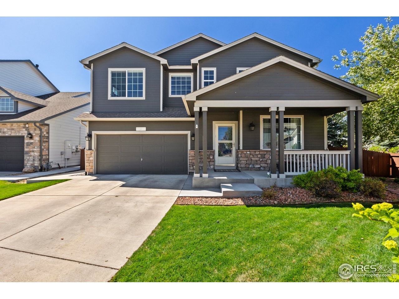 6117 Gold Dust Road Timnath, CO 80547 - Photo 42 of 43 a front view of a house with a yard and porch